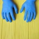 Blue Gloved Hands Closeup on Yellow Wooden Table - VideoHive Item for Sale