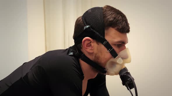Sportsman analysing ECG in sport science lab. Triathlete in oxygen mask