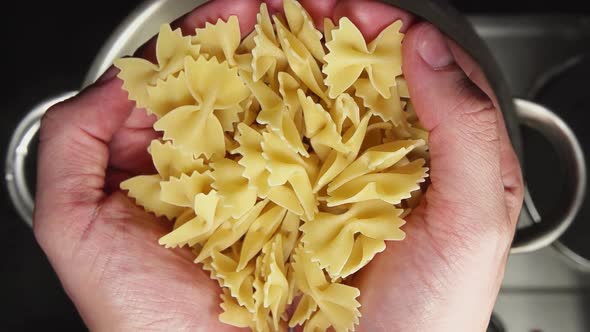 Chief-Cooker's Hands Throw A Noodles Bows In A Steel Pan