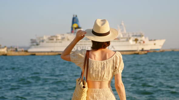 Happy girl in hat looking at the sea, video 6k