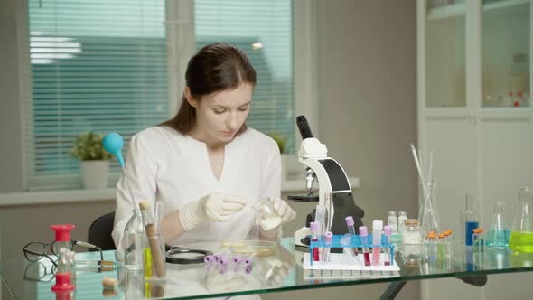 Female Doctor In Laboratory With Microscope alt