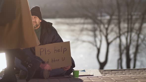 Passing By Woman Spares Coins To Homeless Man