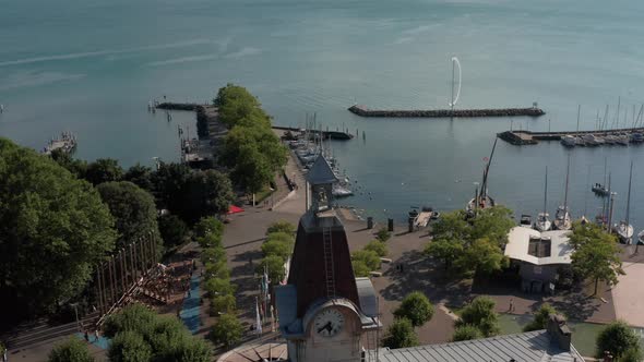 Jib down of old clock tower overlooking beautiful lake Geneva