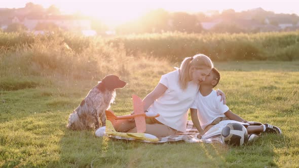 Mom and Son Are Resting in the Park with Their Dog