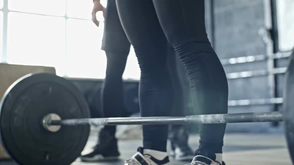 Woman Doing Barbell Front Squats with Coach