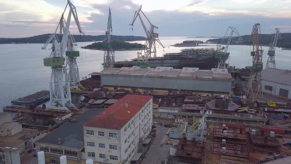 Abandoned Shipyard With Unfinished Cargo Ship In Twilight