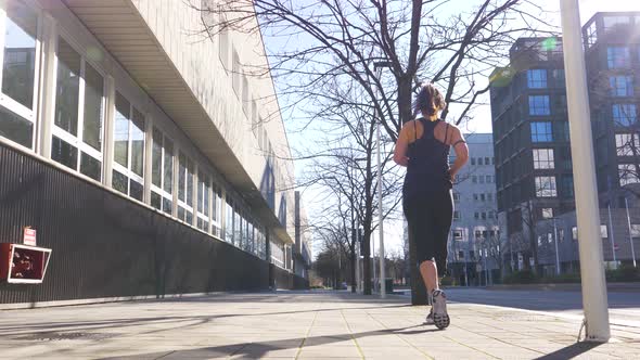 Slow motion shot of jogging woman with leg prosthesis in the city