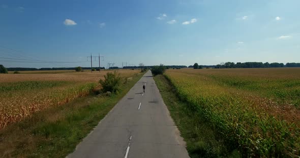 Cycling Exercise From Drone. Aerial Cyclist Triathlete Ride On Rural Road. Aerial Triathlon Cyclist.