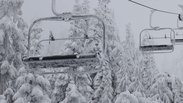 Chairlift at Ski Resort Covered in White Snow During a Snowy Winter Season Day