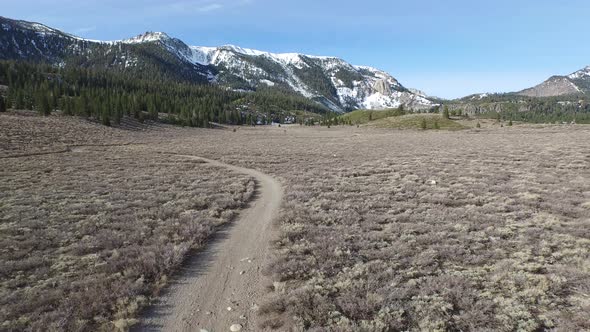 Aerial shot of young woman trail running in the mountains.