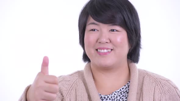 Face of Happy Overweight Asian Woman Giving Thumbs Up Ready for Winter