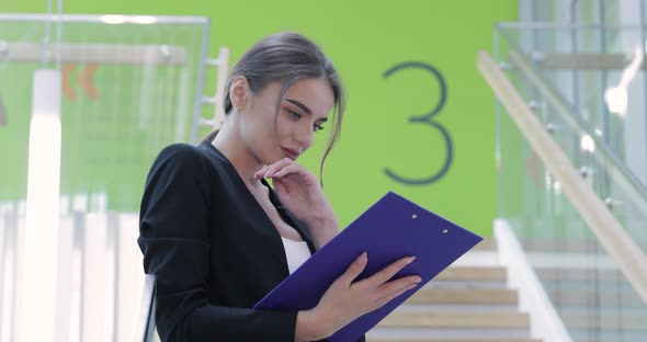 Business Woman With Folder In Hands In Office Building