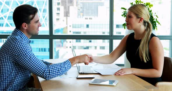 Executives interacting with each other at desk