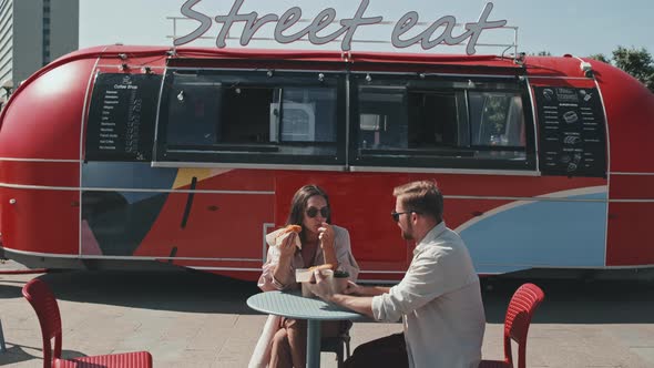 Couple Eating Street Food and Talking Outdoors in Summer