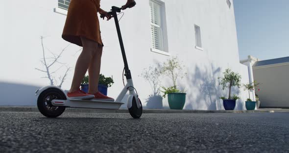 Two mixed race women riding electric scooter