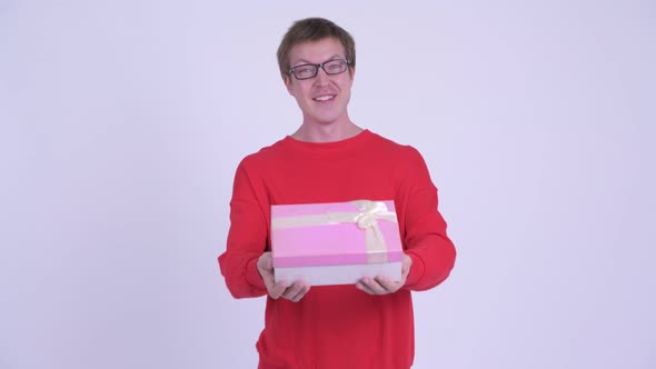 Happy Young Handsome Man Giving Gift Box