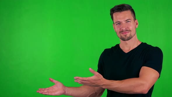 Young Handsome Caucasian Man Introduces Something - Green Screen - Studio