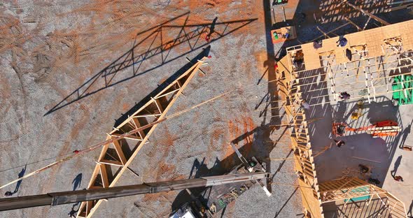 Aerial View of Wooden Roof with Crane Holds a Roof Truss Beams for Installing