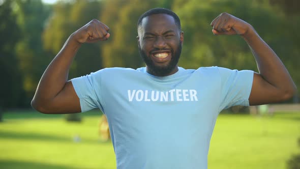 Excited African Male Volunteer T-Shirt Showing Strength Gesture, Donation Unity