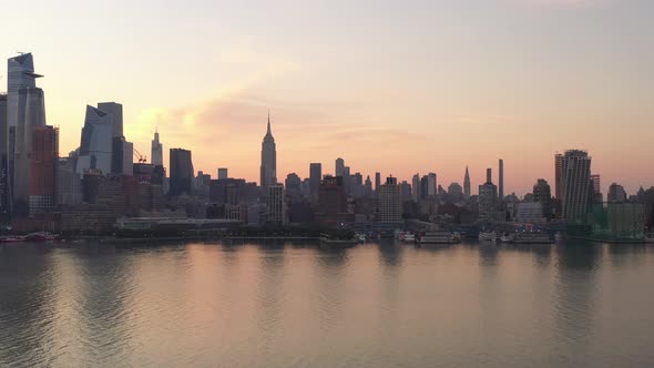 An aerial shot of Manhattan's westside at sunrise on a hazy morning. The camera tilt up and dolly in
