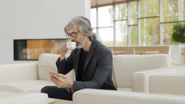 Senior Man With Digital Tablet At Lounge Zone