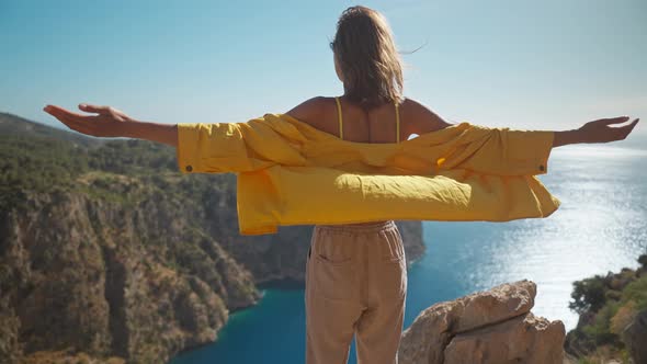 Slow Motion Rear View Freedom Filling Woman with Raising Arms Enjoying Beautiful View of Butterfly