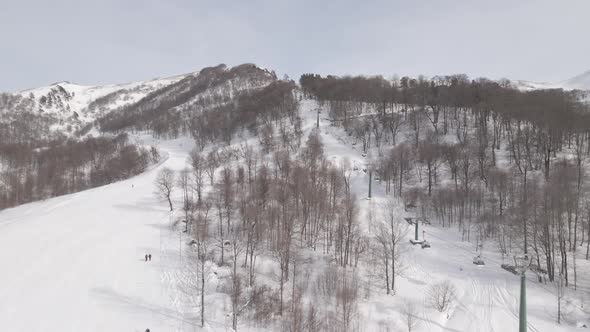 Flying over rope-way with gondolas at mountain resort Crystal Park in Bakuriani. Snowy winter day.