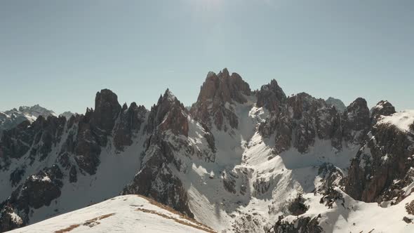 Circling drone shot of Candini group mountains in the snow