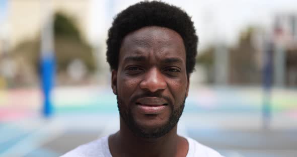 African man looking on camera outdoor in court basketball camp