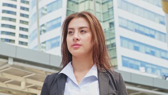 Portrait of Asian young smart businesswoman stand with smile in city while walk to company office.