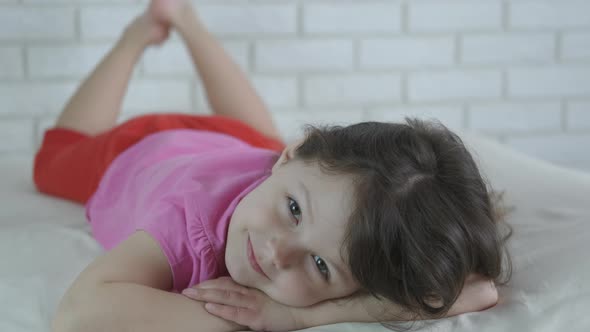 Cute kid lies on the bed. 