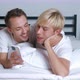 Young Gay Couple Lying on Bed in Bedroom and Using Smartphone Together - VideoHive Item for Sale