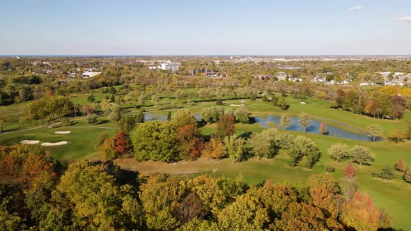 Aerial of beautiful golf course surrounded by forest. Fall.