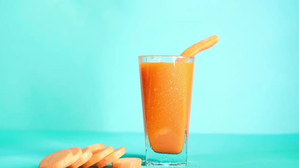 Healthy smoothie carrot juice vegetable cocktail tube on blue background