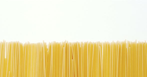 Raw spaghetti arranged on white background