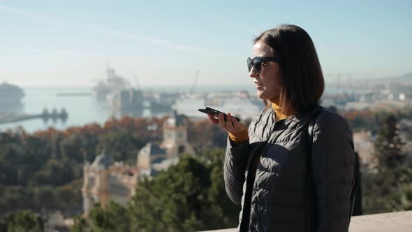 Portrait of Smiling Woman Using Smartphone Voice Recognition