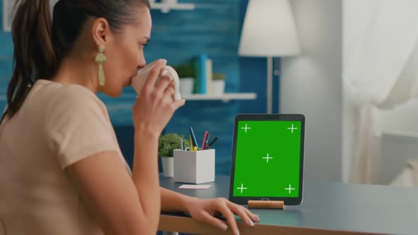 Freelancer Woman Holding Cup of Coffee Looking at Tablet Computer