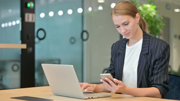 Businesswoman Using Smartphone and Laptop 