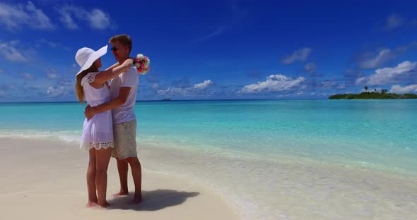 Beautiful man and woman after marriage in love spend quality time on beach on clean white sand 