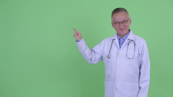 Happy Mature Japanese Man Doctor Touching Something