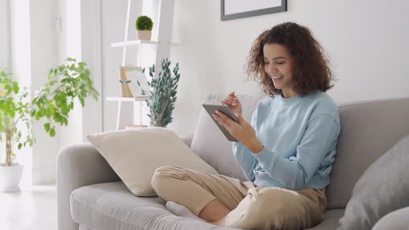 Happy Teen Girl Using Tablet Enjoying Online Virtual Chat Video Call at Home