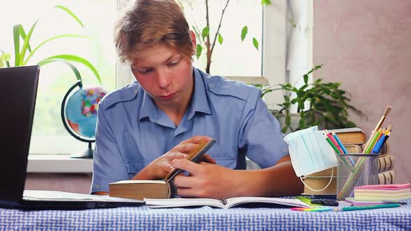 a Young Teenager Man in a Blue Shirt of European Appearance Sits