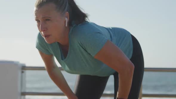 Senior woman taking a break from running on a promenade