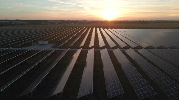 Aerial Drone View Into Large Solar Panels at a Solar Farm at Bright Sunset. Solar Cell Power Plants