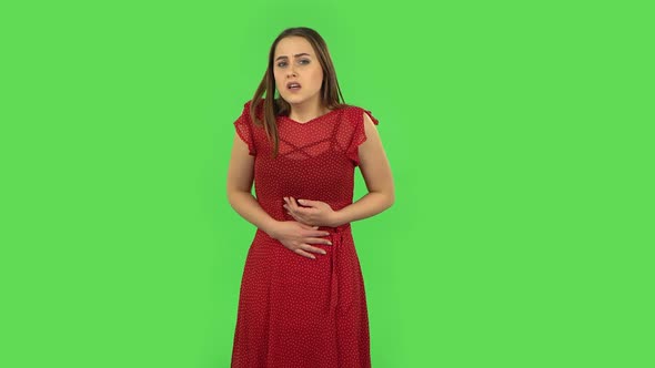 Tender Girl in Red Dress Is Feeling Very Bad, Her Stomach Hurting. Green Screen