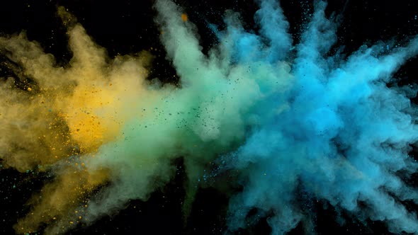 Colorful powder/particles fly after being exploded against black background. Slow Motion. alt