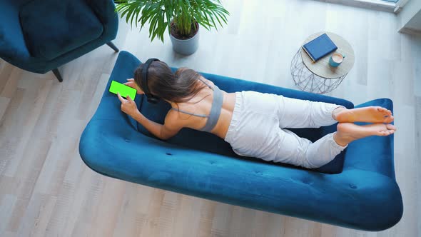 Woman in Wireless Headphones Listening to Music and Using Mobile Apps or Communicates on Social