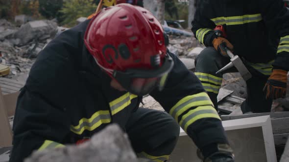 Male Emergency Service Worker Inspecting Rubble