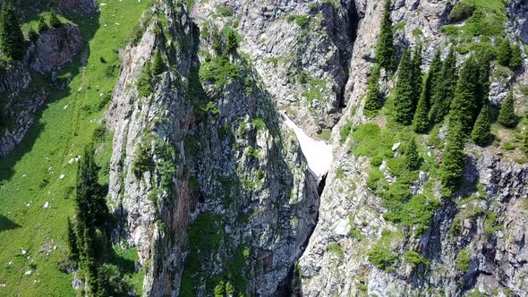 Top View of Steep Mountain Cliffs and an Ice Cave