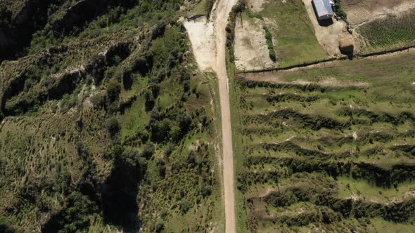 Aerial view showing a house with the shed and slowly zooming in at the dirtroad next to it